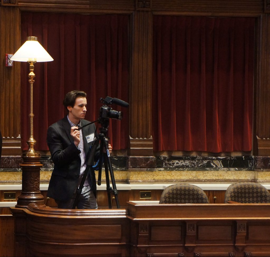 2016 session intern Rob Uniacke operating a camera in the Senate Chamber. 